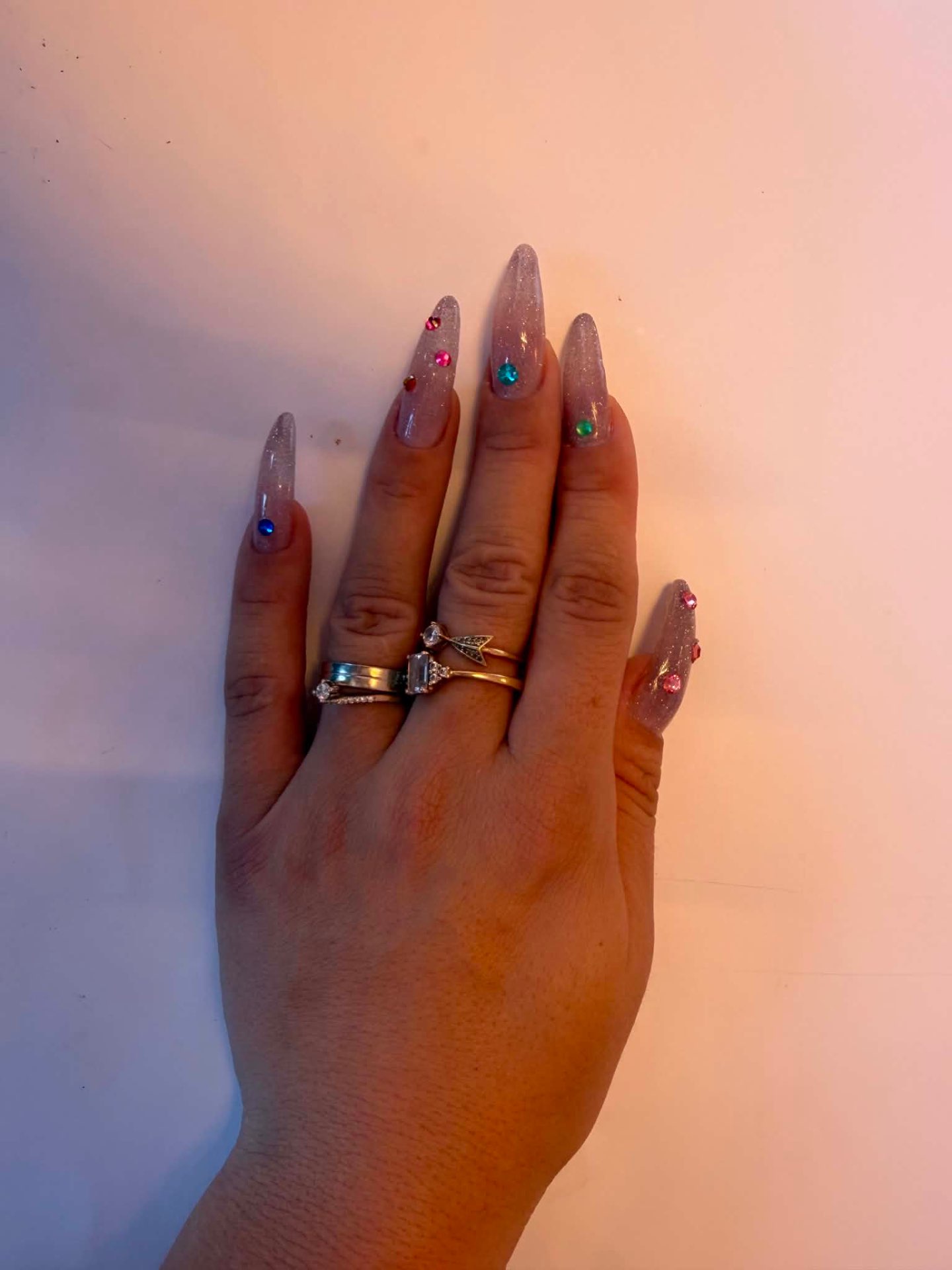 Glitter nude nails with coloured gem accents
