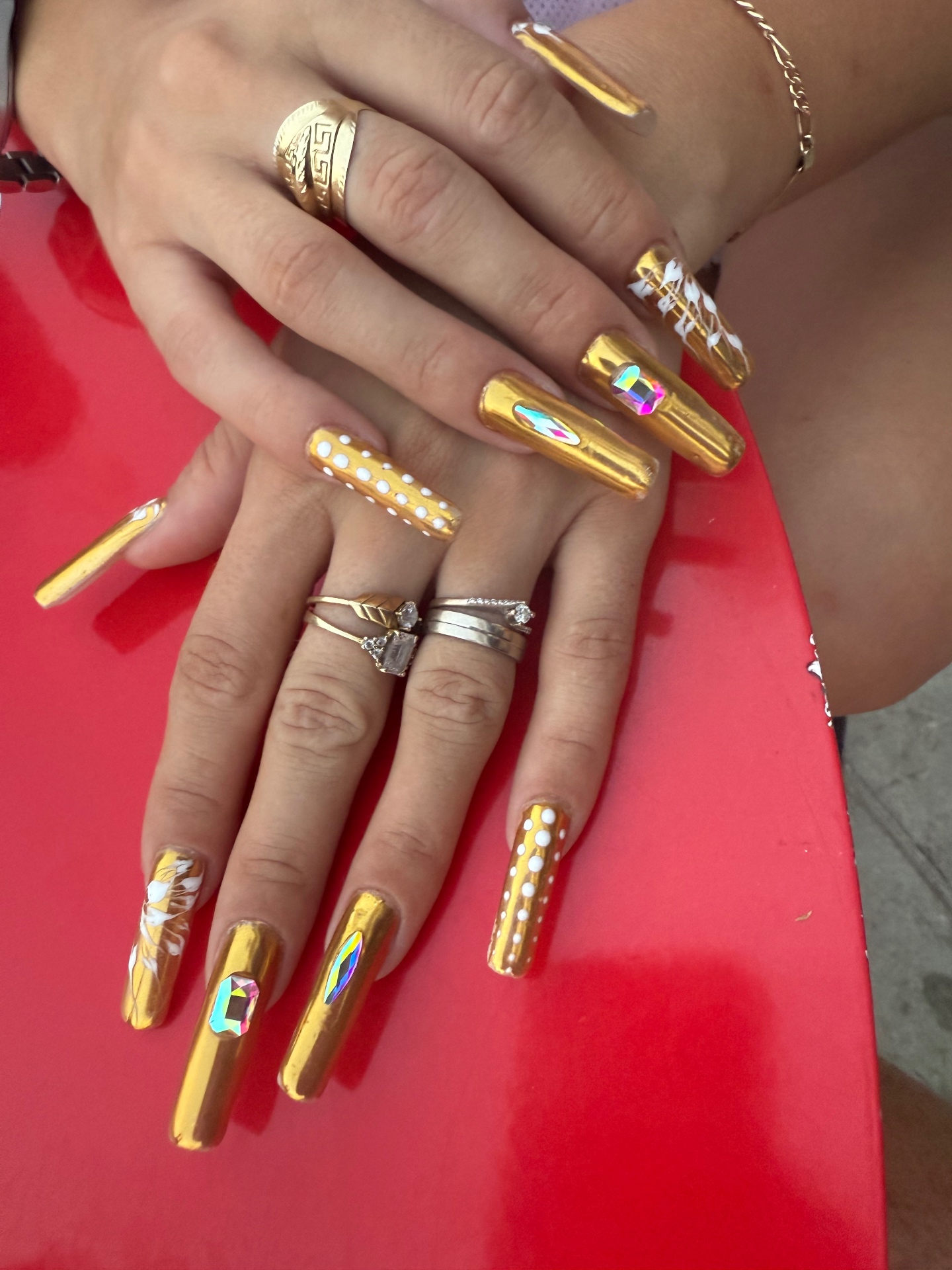 Long gold chrome nails with crystals and white dot art